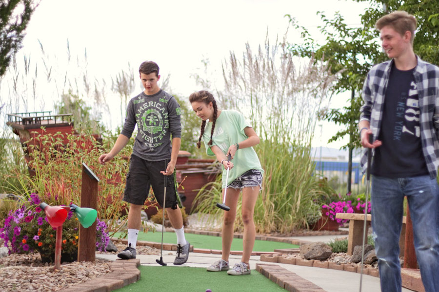 Three Guests Playing Mini Golf