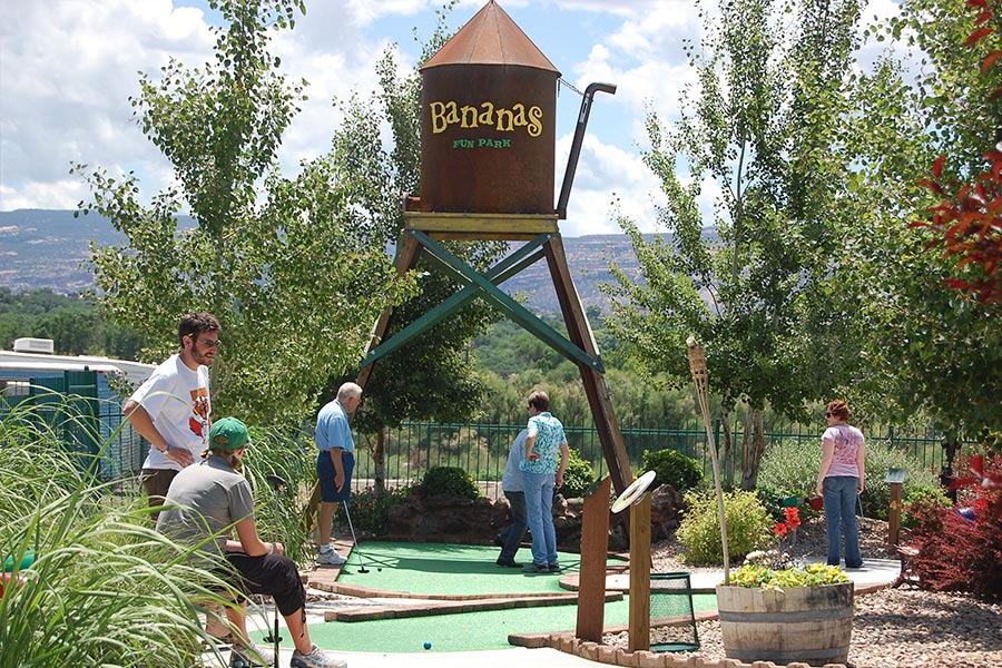 Guests Playing Miniature Golf Near Water Tower