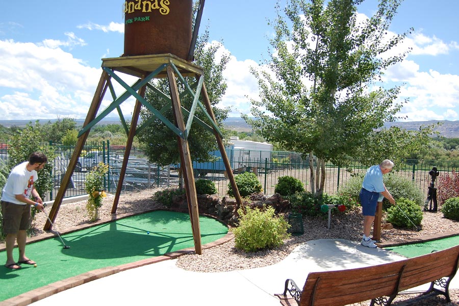 Guests Playing Miniature Golf Near Water Tower